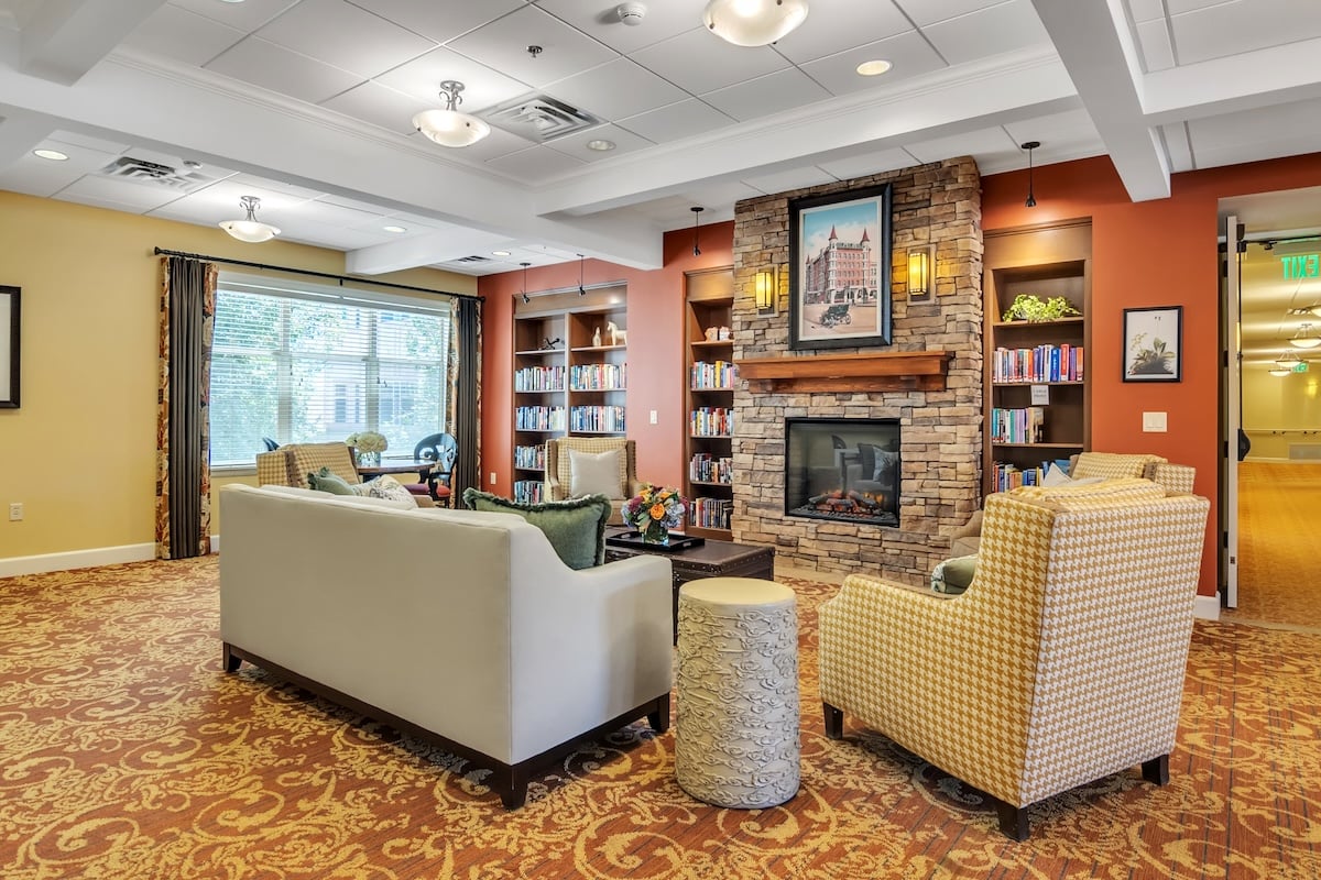 Common area with white couch, fireplace and bookshelves
