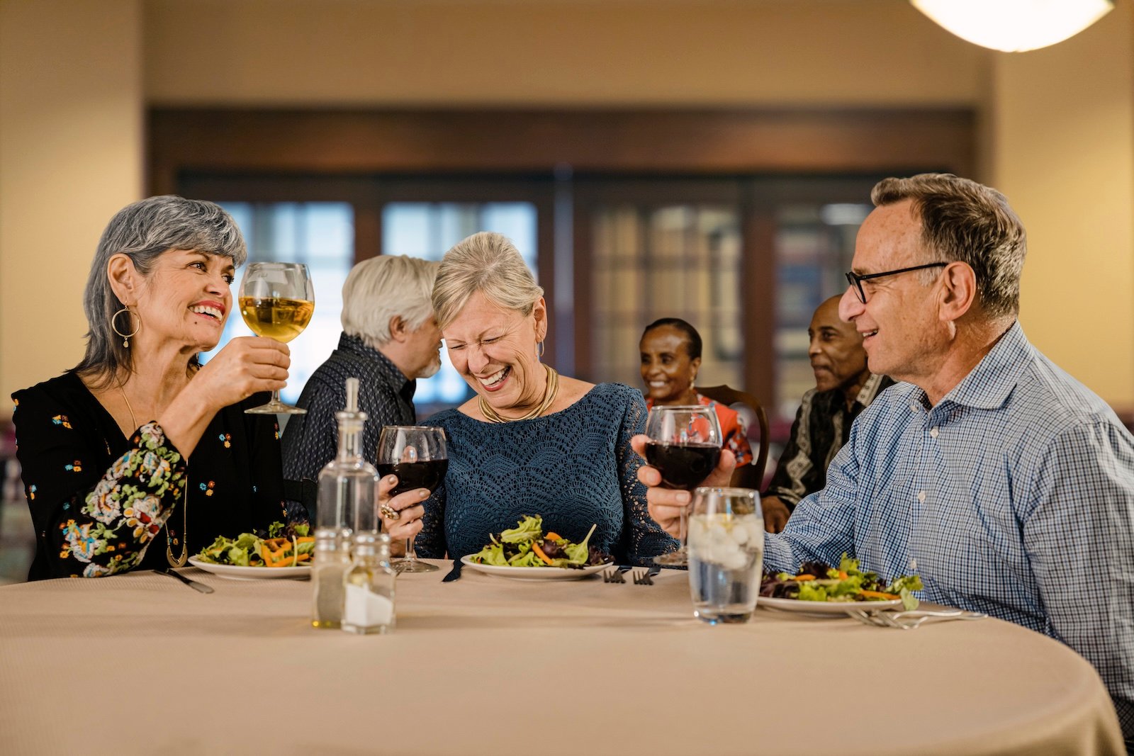 senior friends enjoying dinner at a restaurant