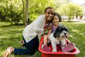 grandmother and grandchild posing together with the family dog