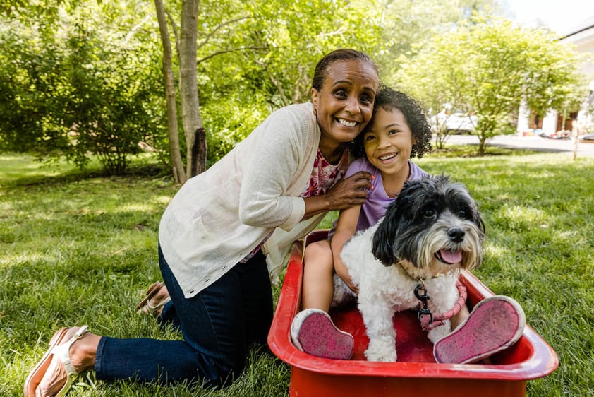 grandmother and grandchild posing together with the family dog