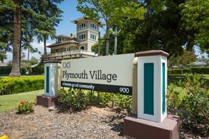 Plymouth Village sign with victorian house in the back