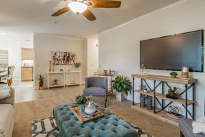 Living room with blue ottoman and television