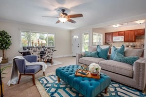 Living room with blue tufted ottoman