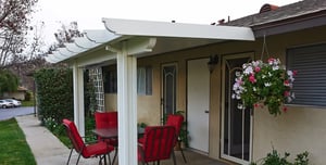 House patio with 4 red chairs at outdoor dining set