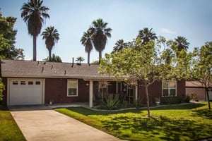Home exterior with tan brick and brown posts