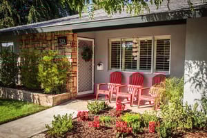 House front door with three red chairs
