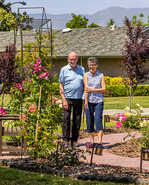 senior standing in beautiful landscaping and mountain views