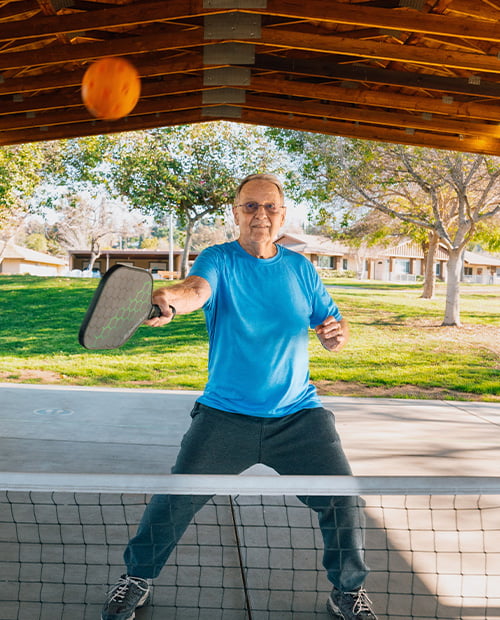Senior playing pickleball court