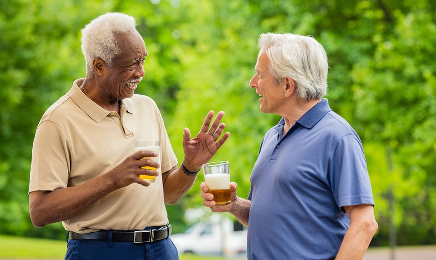 two senior males having a conversation while drinking beer