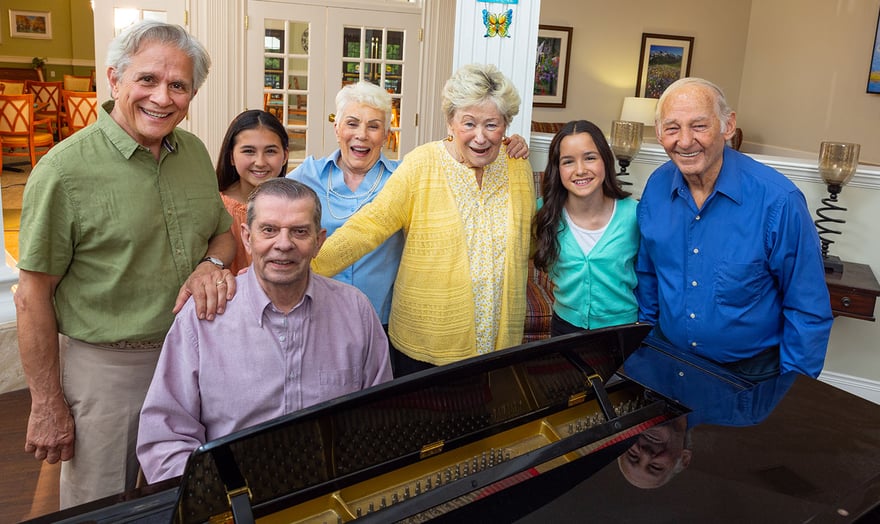 family gathered around a piano smiling