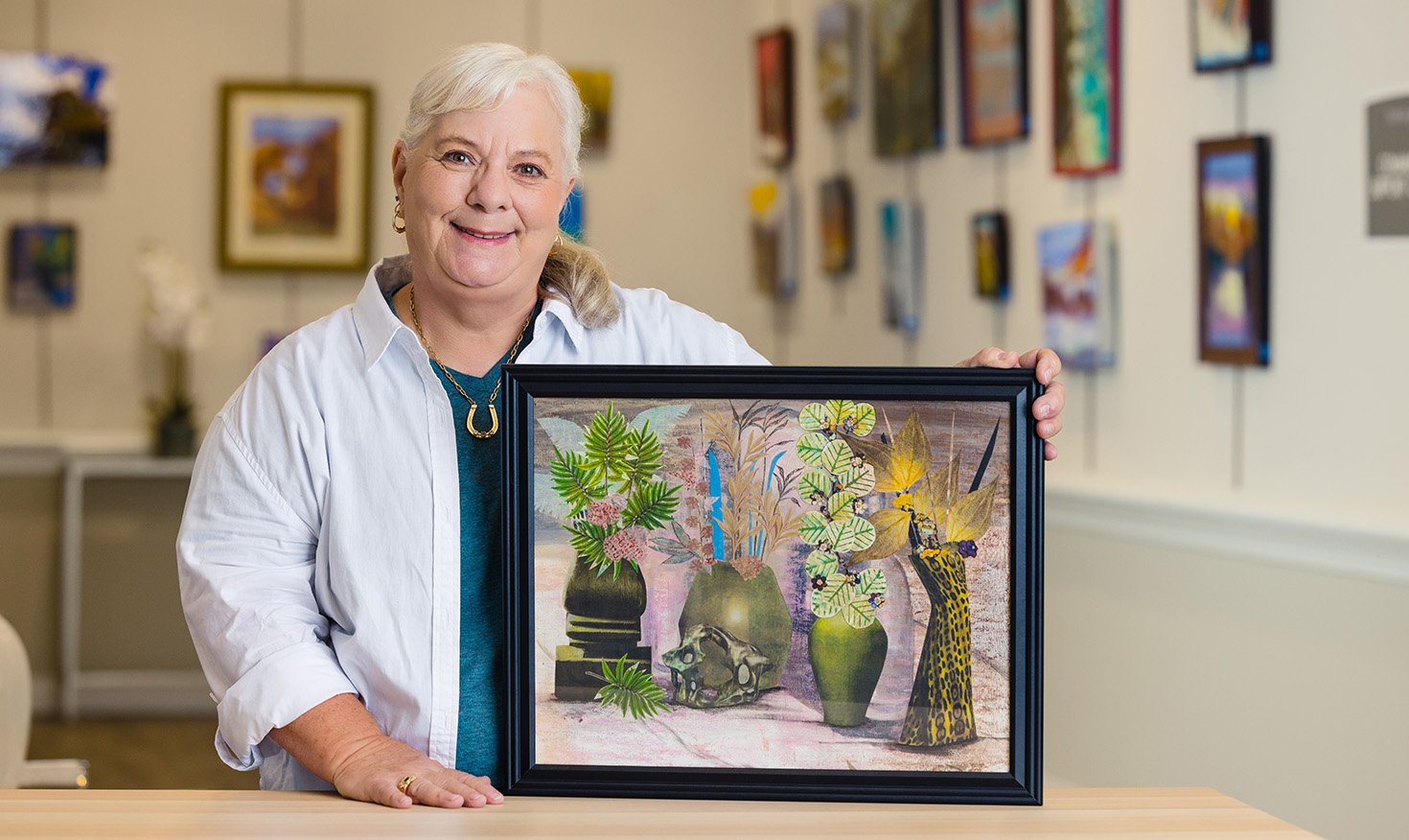 senior posing with her art at an art show