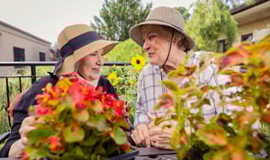 seniors wearing sun hates outside while gardening