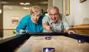 seniors playing table shuffleboard