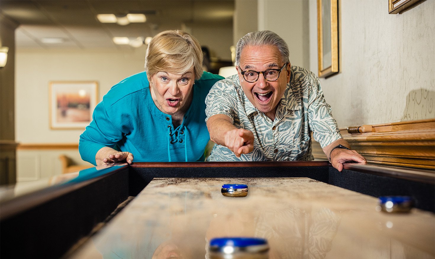 seniors playing table shuffleboard