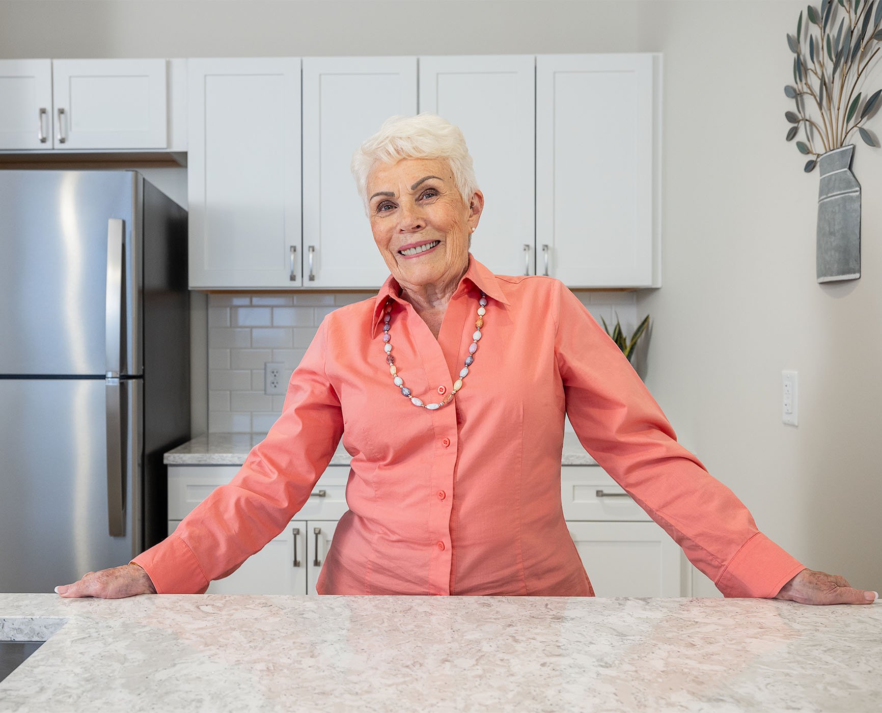senior standing in her modern kitchen