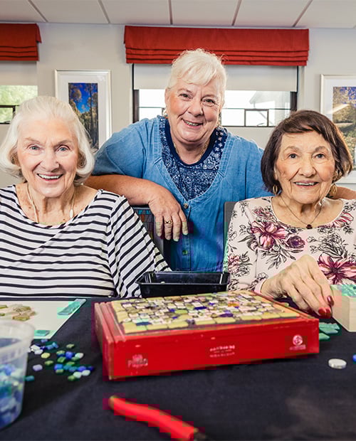 seniors smiling while doing crafts