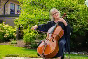 resident playing cello outdoors
