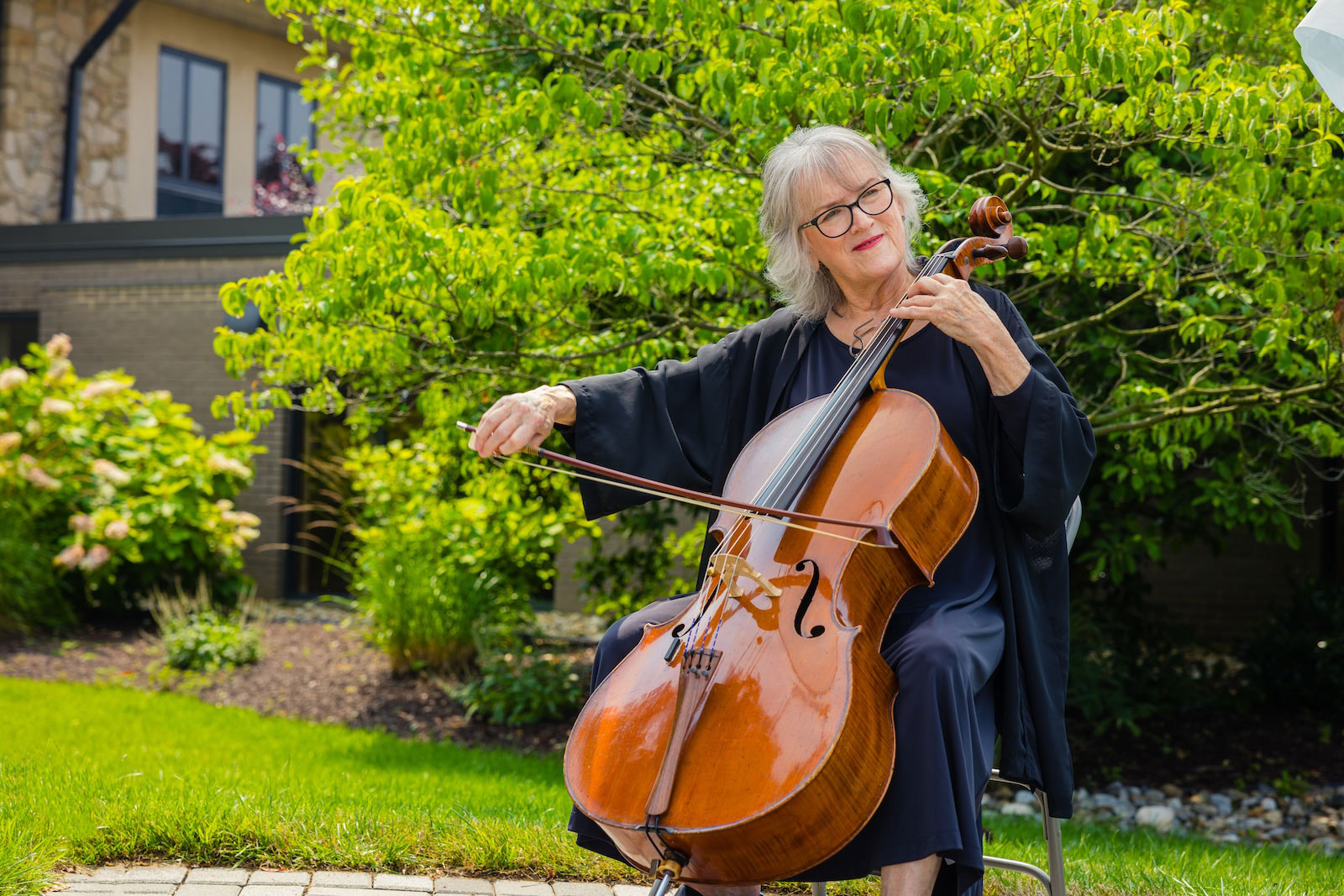 resident playing cello outdoors