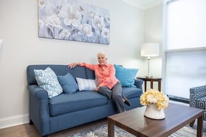 resident sitting on couch inside apartment
