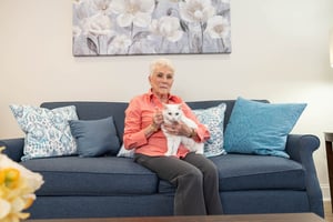 resident sitting on couch with white cat