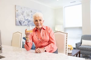 senior resident enjoying wine in apartment kitchen