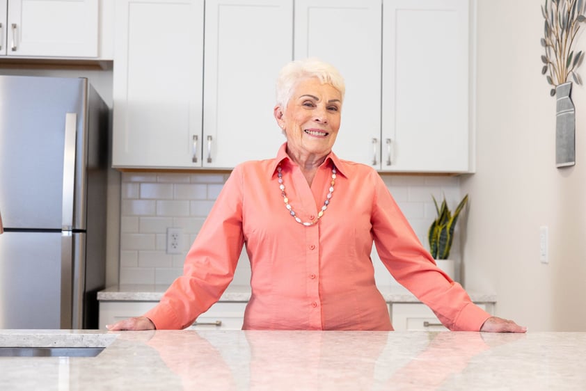senior standing in apartment kitchen