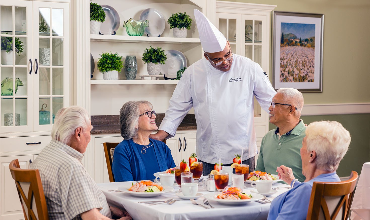 Two senior men and two senior women talking to the chef at their table in the Spring Mill Pointe dining room